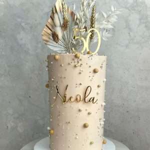 Personalised acrylic birthday cake topper with name and age in gold.